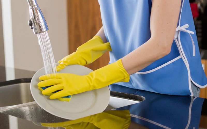 Đeo găng tay khi rửa chén để tránh tiếp xúc với hóa chất độc hại