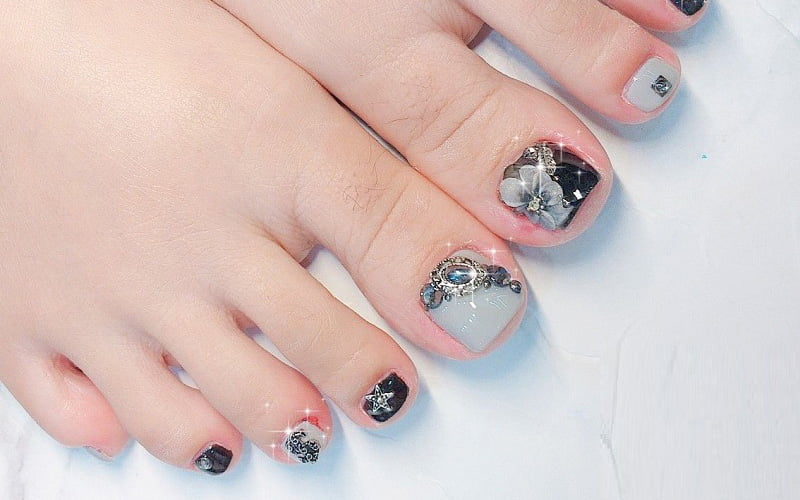 Bạn có thể tăng thêm phần thu hút khi kết hợp hoa văn và đính đá trên nail chân